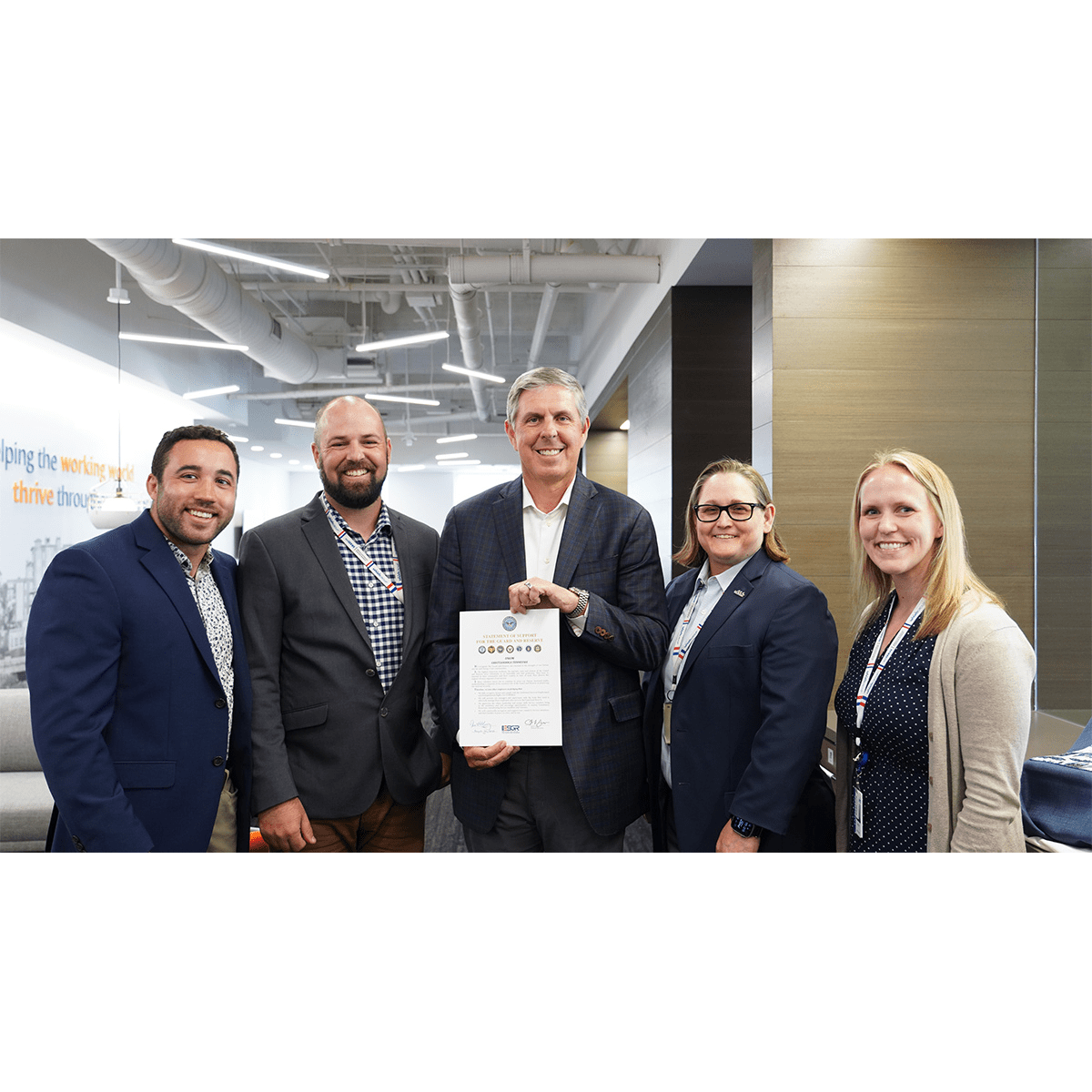Rick McKenney (Unum Group CEO) standing with a group of people showing the signed ESGR pledge